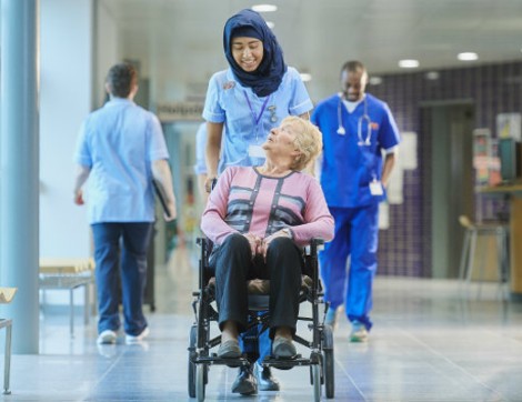 Volunteer pushing woman in wheelchair