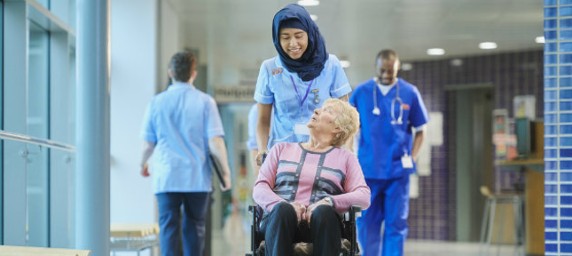 Volunteer pushing woman in wheelchair