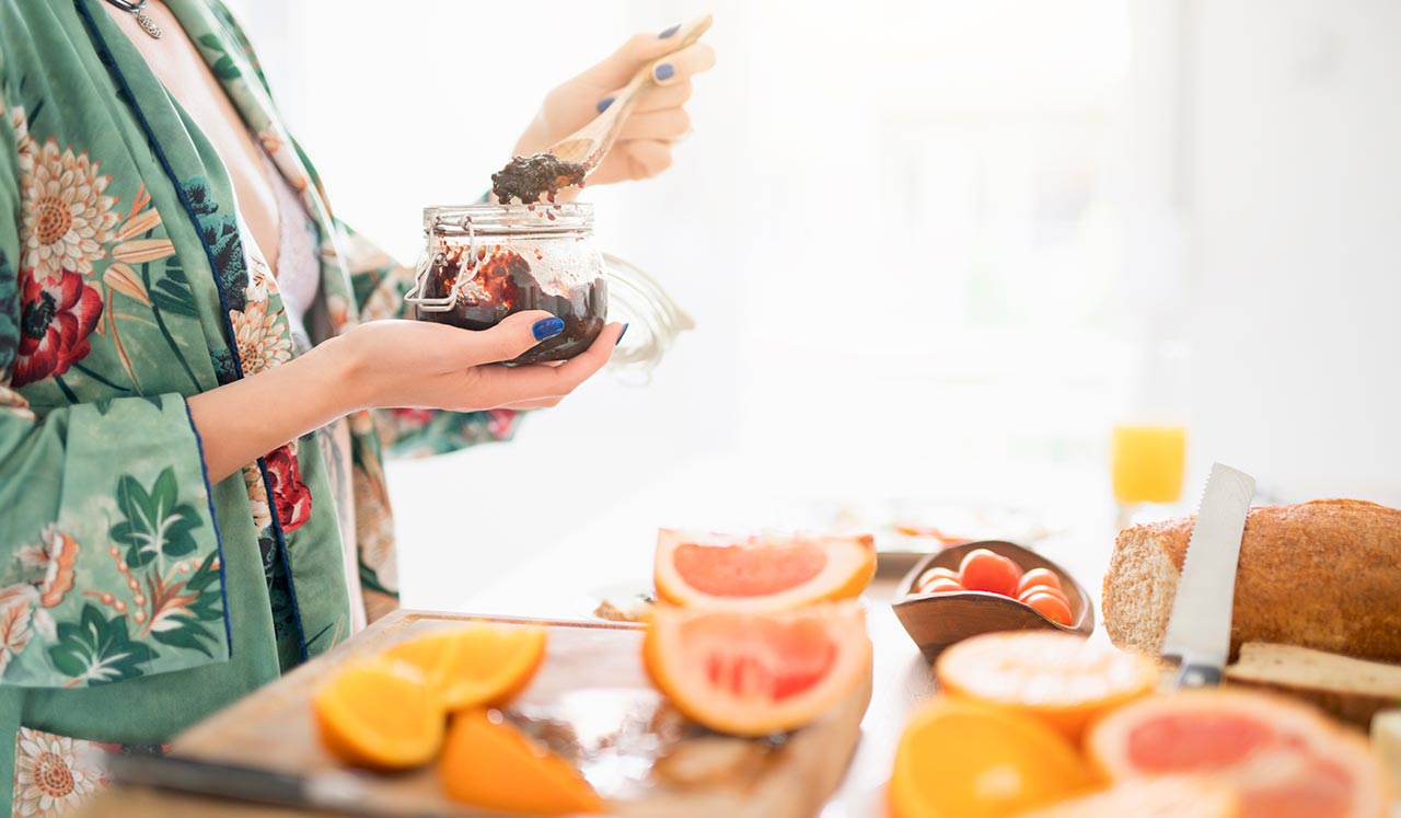 A woman holding a jar of jam