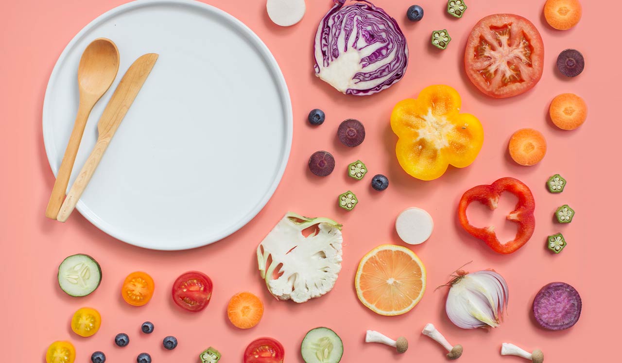 A plate surrounded by slices of fruits and vegetables.