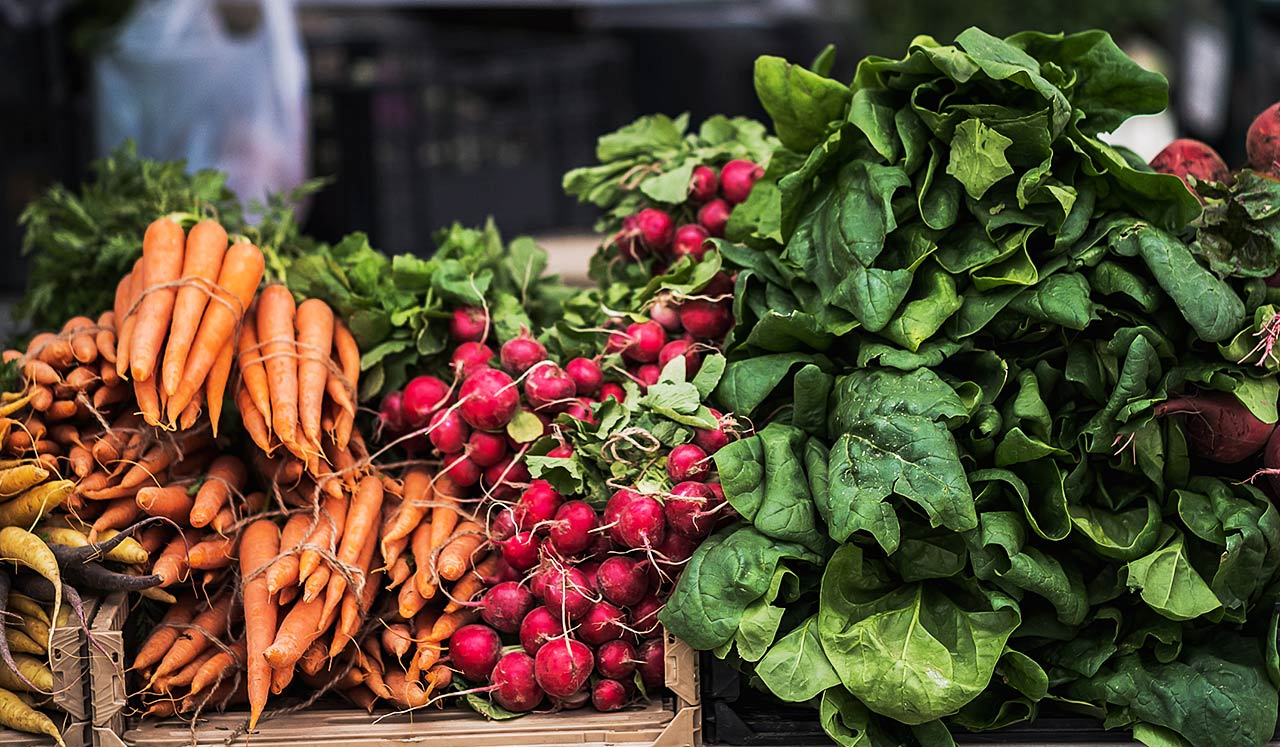 Bunches of carrots and vegetables at a farmers market.