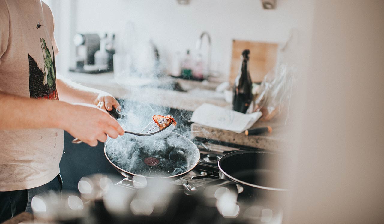 A man cooking food on the stove.