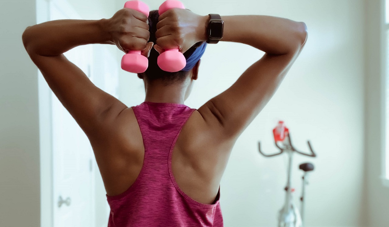 A woman doing arm exercises with hand weights.