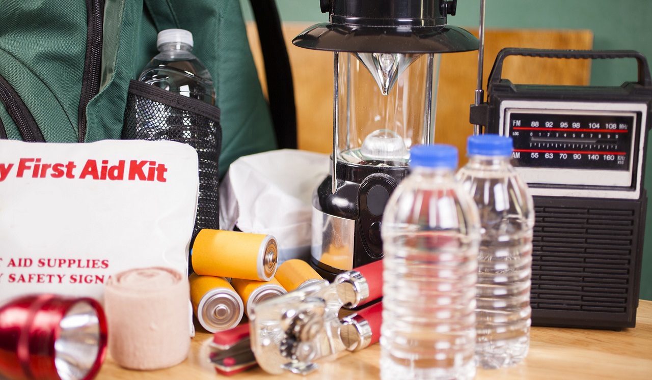 First aid kit, bottled water, a flash light and other items for an emergency kit.