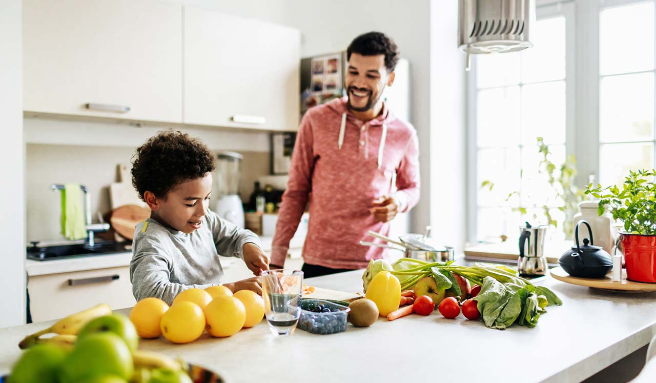 Father and son smiling in the kitchen