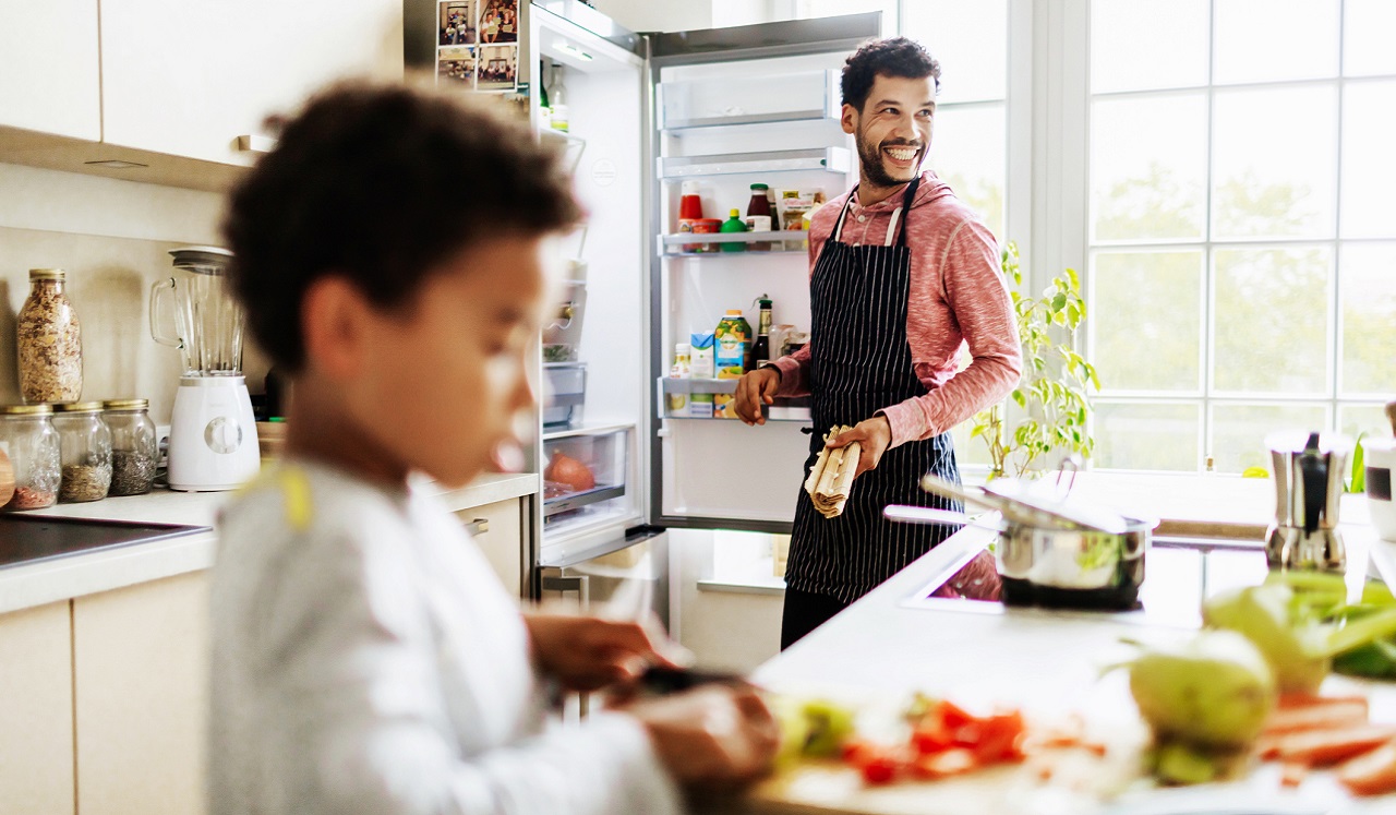 A father and son preparing a meal in the kitchen.