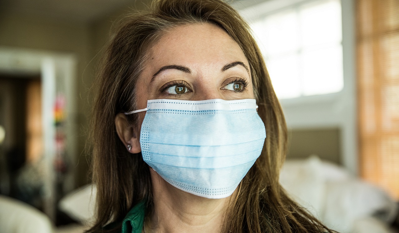 A vaccination record card and face mask on a table.