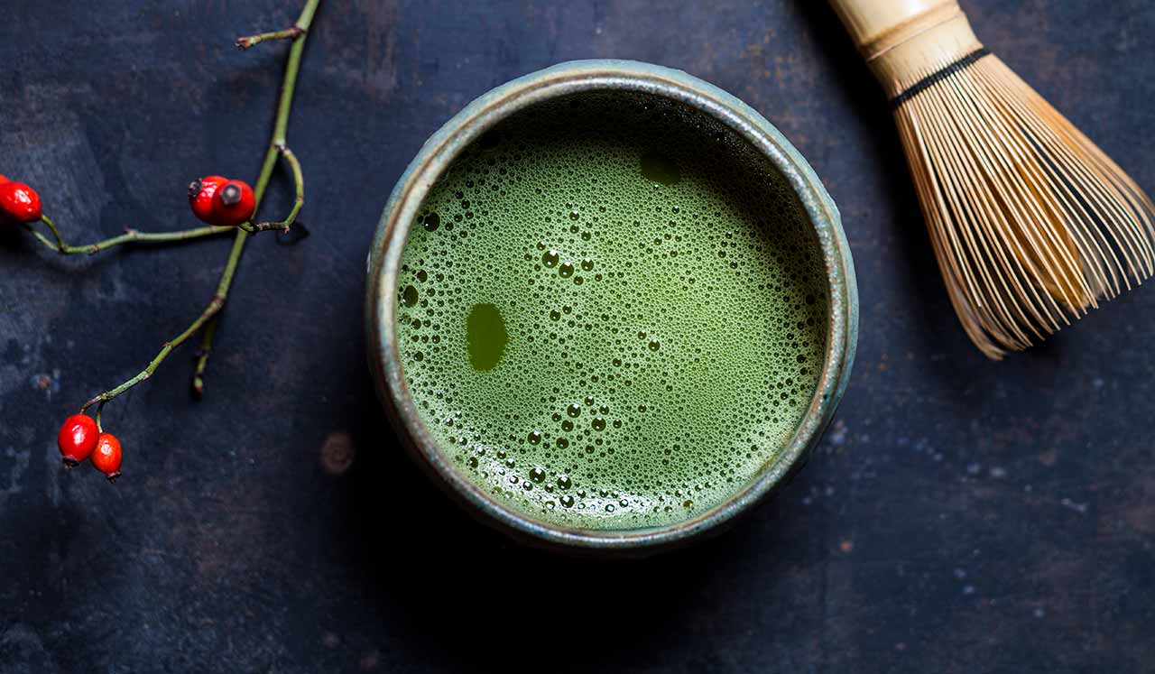 An aerial view of a green smoothie in a cup.