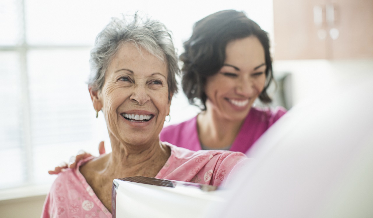 Two women smiling at each other.