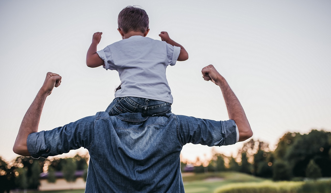 A child on his fathers shoulders outdoors