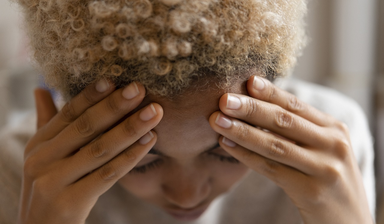 Woman holding her forehead as if in pain