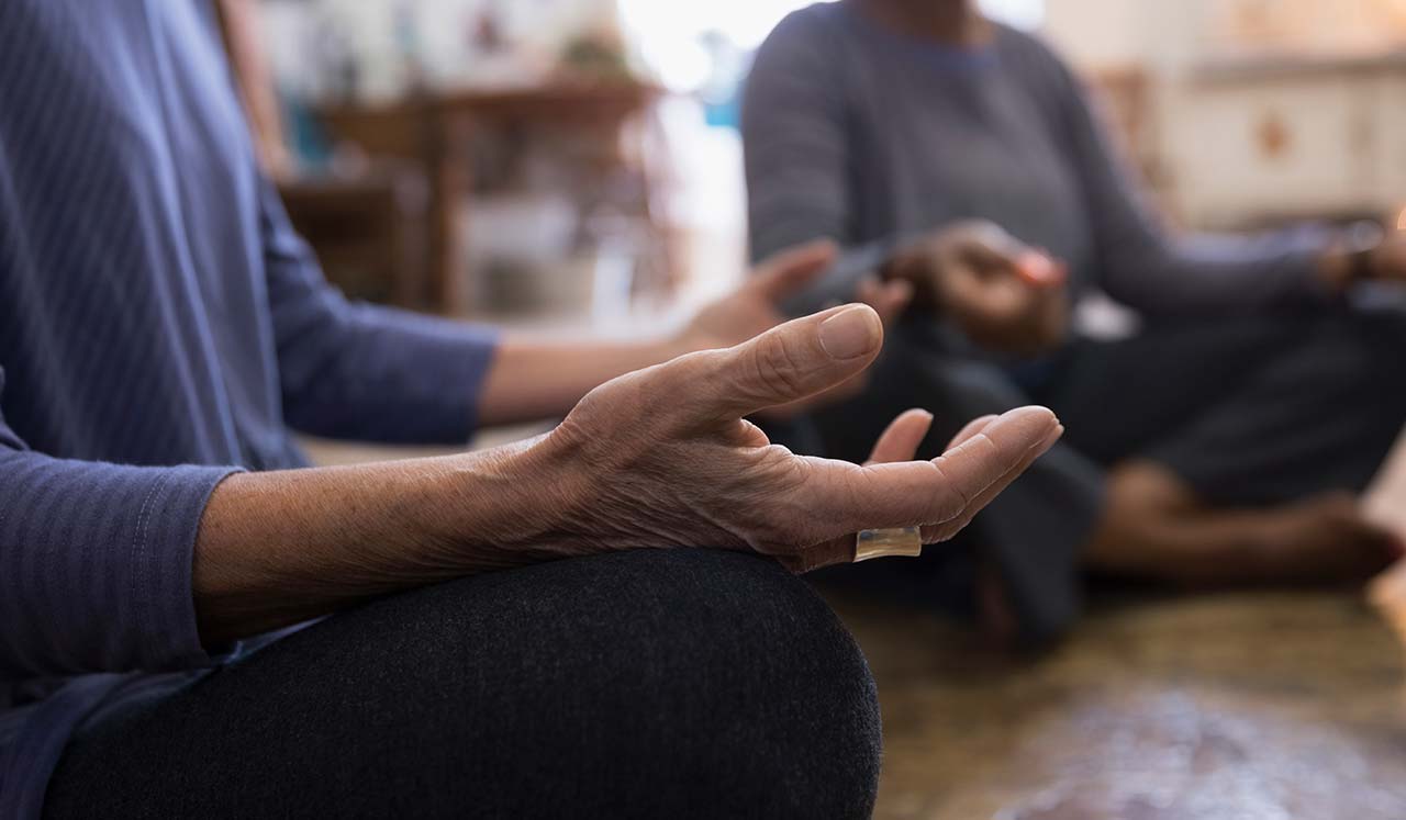 Two people siting in a meditative pose.