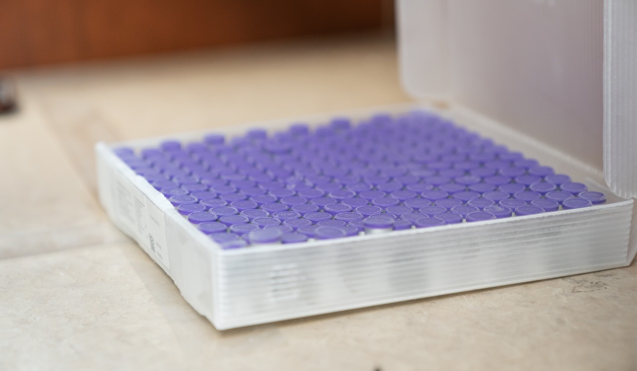 A tray of purple-topped medical vials.