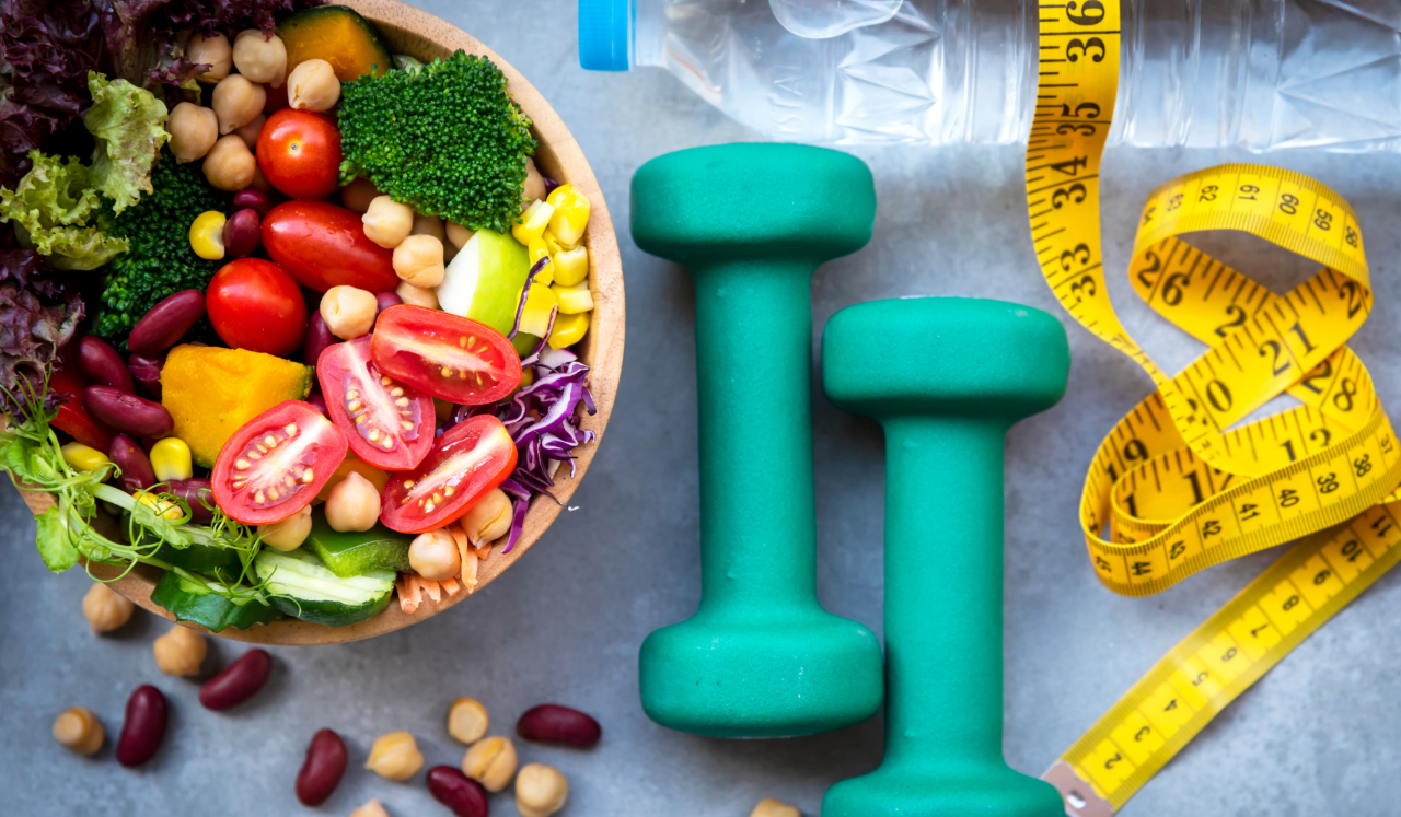 Weights alongside a bowl of fresh vegetables