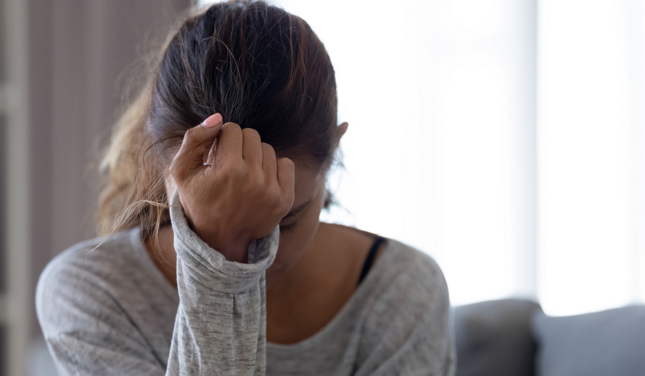 A woman holding her fist to her head as if in frustration.