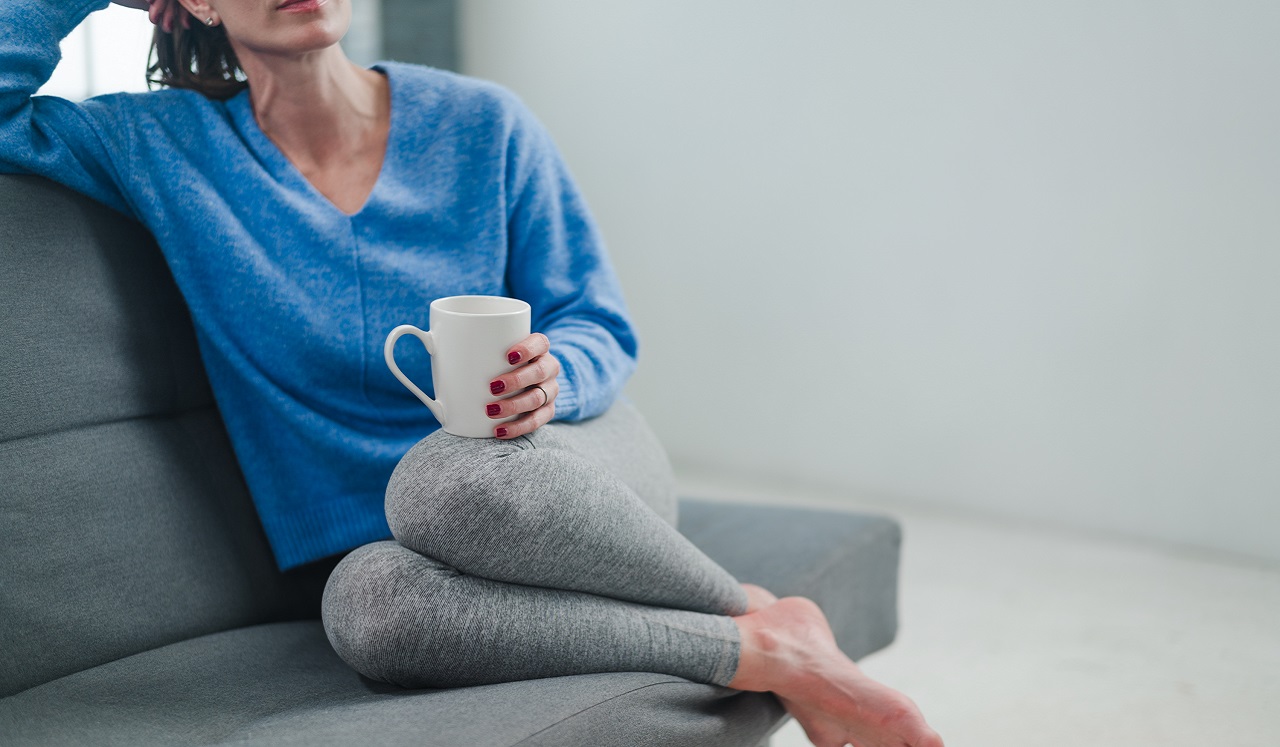 A woman relaxing while holding a cup of tea.