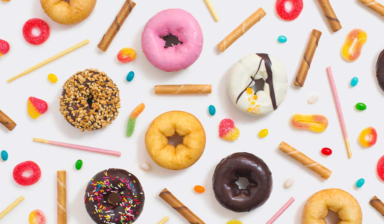 A variety of donuts and other sugary snacks arranged in a pattern.