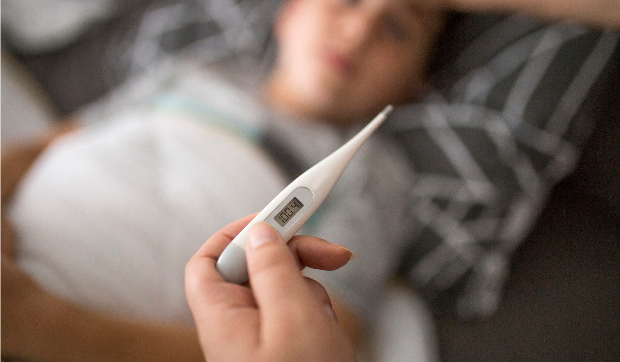 A digital thermometer with child in background