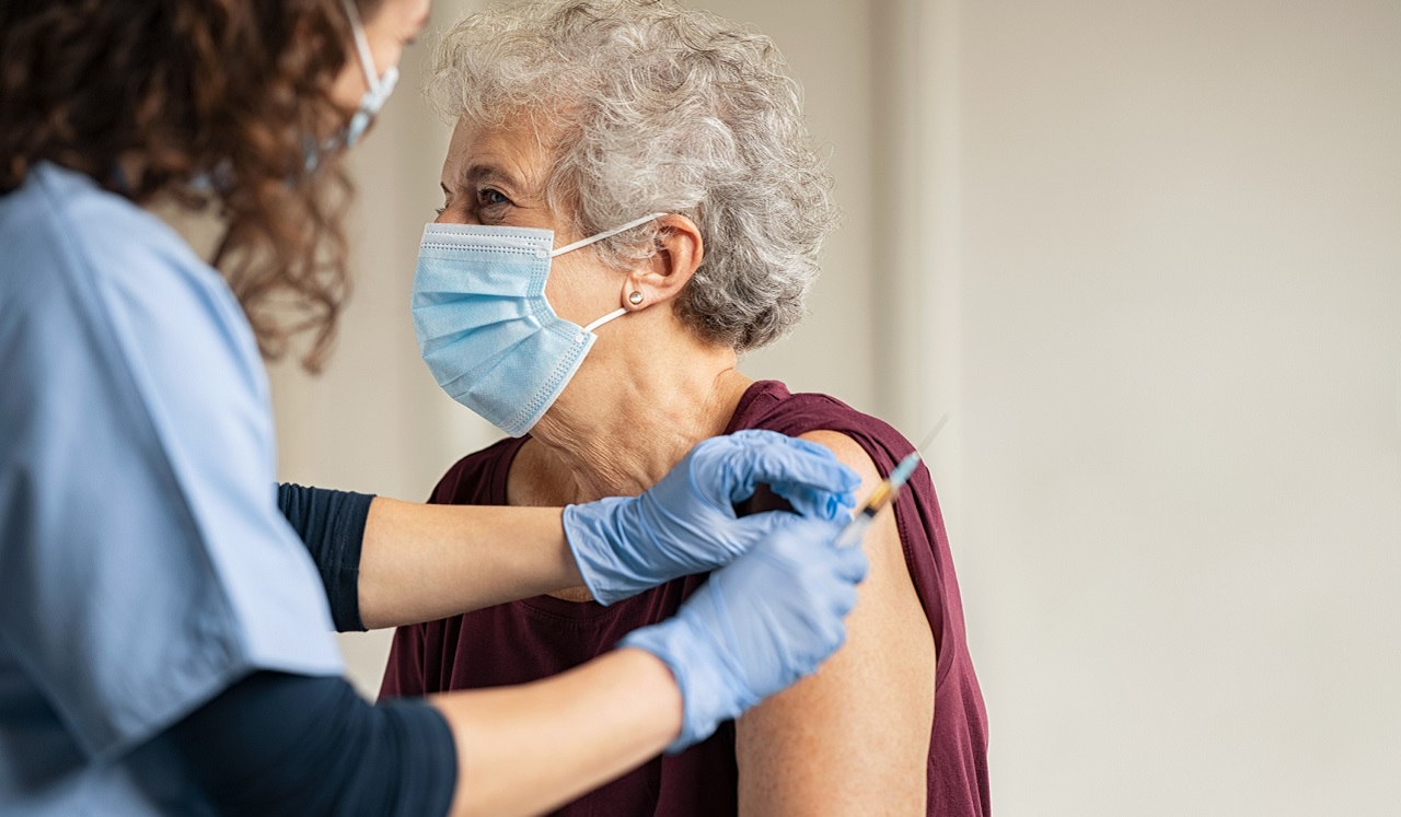 A vaccination record card and face mask on a table.