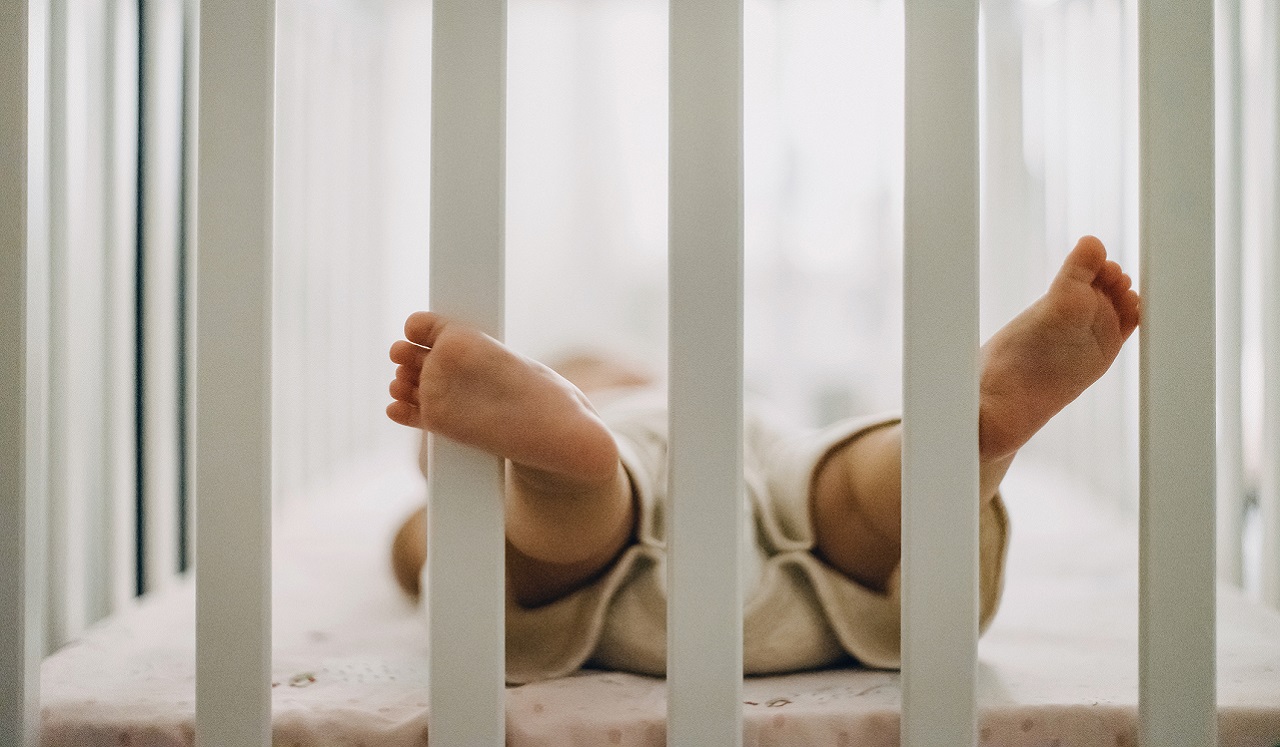 A baby laying in a crib