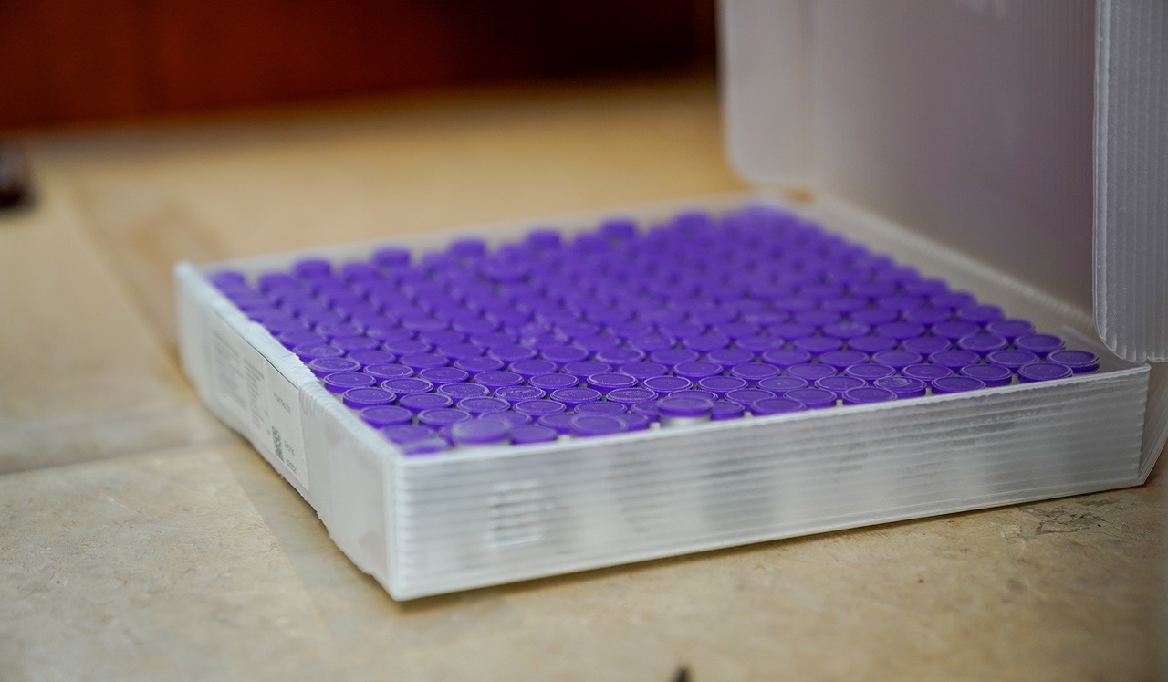 A tray of purple-topped medical vials