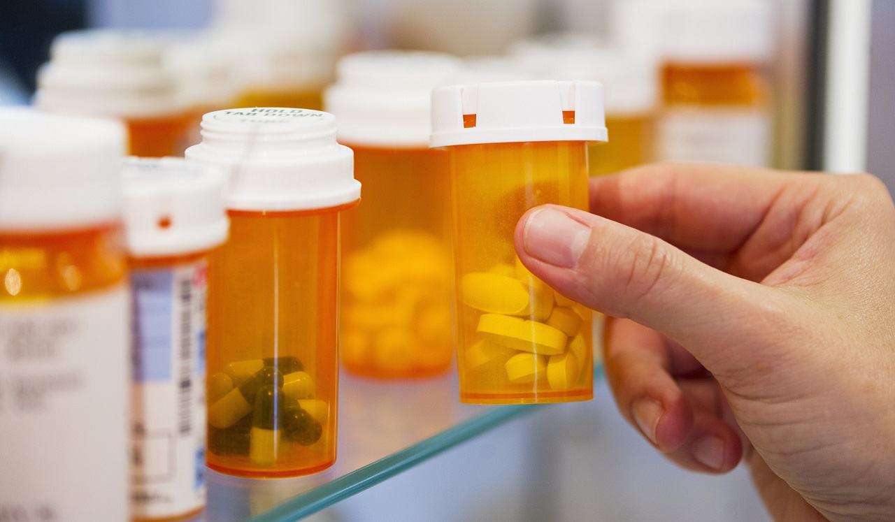 Person adding medicine to their cabinet