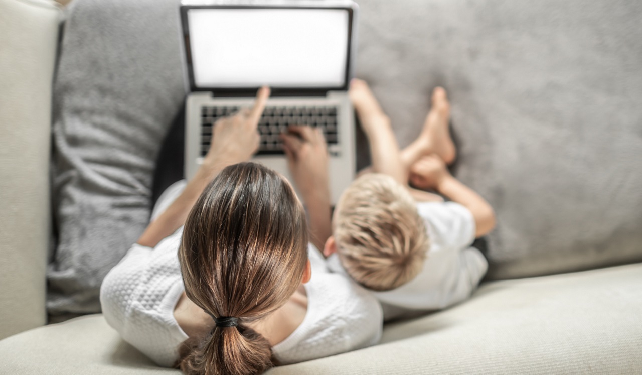 An aerial view of a woman and her young son looking at a computer screen.