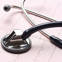 A stethoscope placed on printed heart-rate graphs.