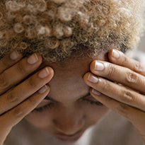 Woman holding her forehead as if in pain