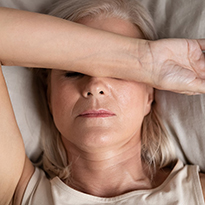 Woman laying down with arm across her head