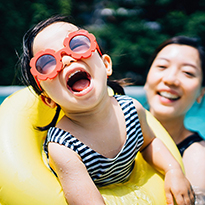 A mother and her toddler having fun in the swimming pool.