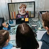 Children looking at their grandmother on a screen