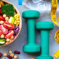 Weights alongside a bowl of fresh vegetables