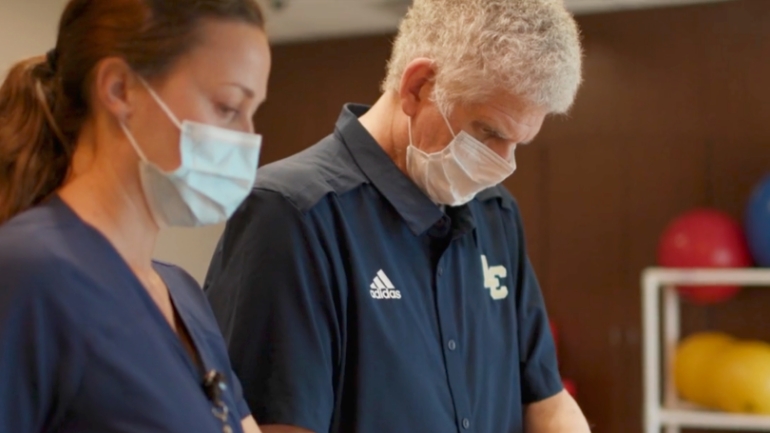 A TIRR Memorial Hermann patient works along side his therapist.