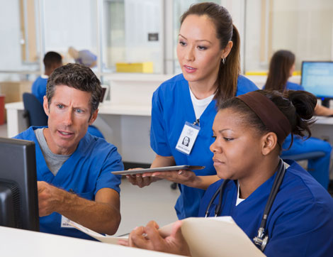 Nurses talking and looking at computer