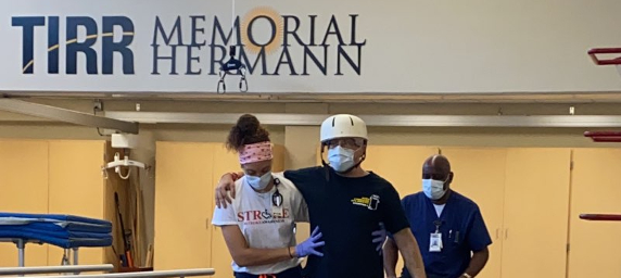 TIRR Memorial Hermann patient, Eric Blumentritt, walks with therapists at the track.