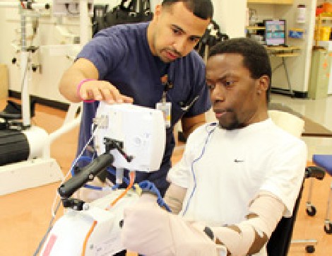 TIRR Memorial Hermann patient, Braxton Taylor, works with therapist and assistive device after spinal cord injury.