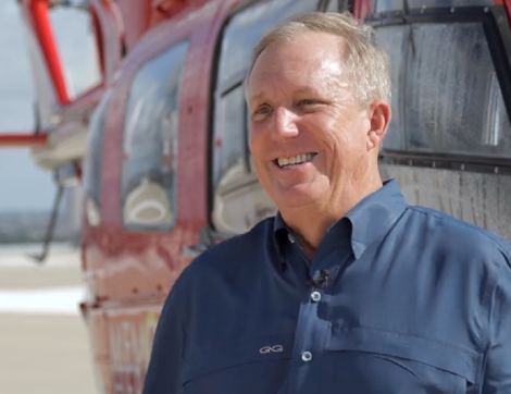 Memorial Hermann Life Flight patient, Brian Bremser, stands near a life-saving helicopter.