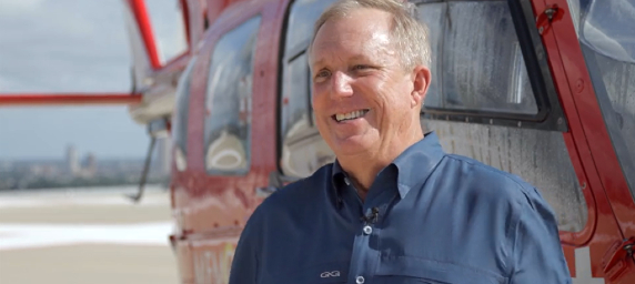 Memorial Hermann Life Flight patient, Brian Bremser, stands near a life-saving helicopter.