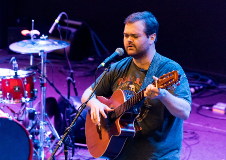 TIRR Memorial Hermann patient, Brandon Ray, plays his guitar and sings after recovery.