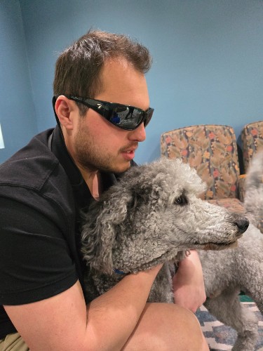 TIRR Memorial Hermann patient, Dallas Matamoros, poses with his service animal. 