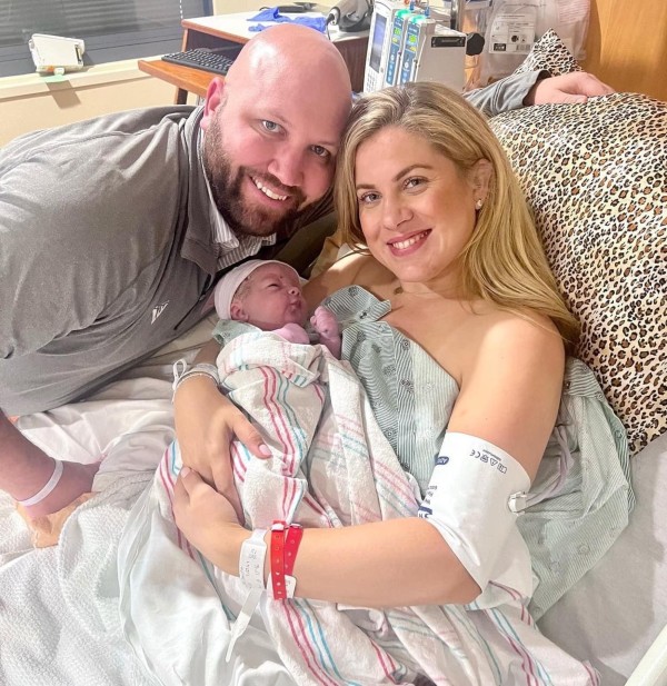 patient posing with newborn in hospital bed