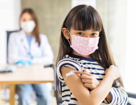 Child showing off vaccine arm