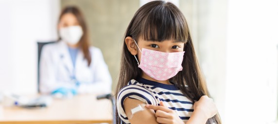 Child showing off vaccine arm