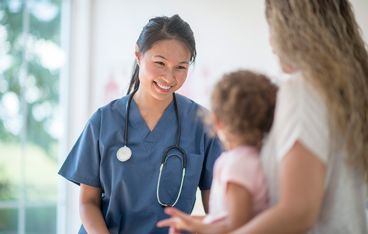 Nurse smiling at child and parent