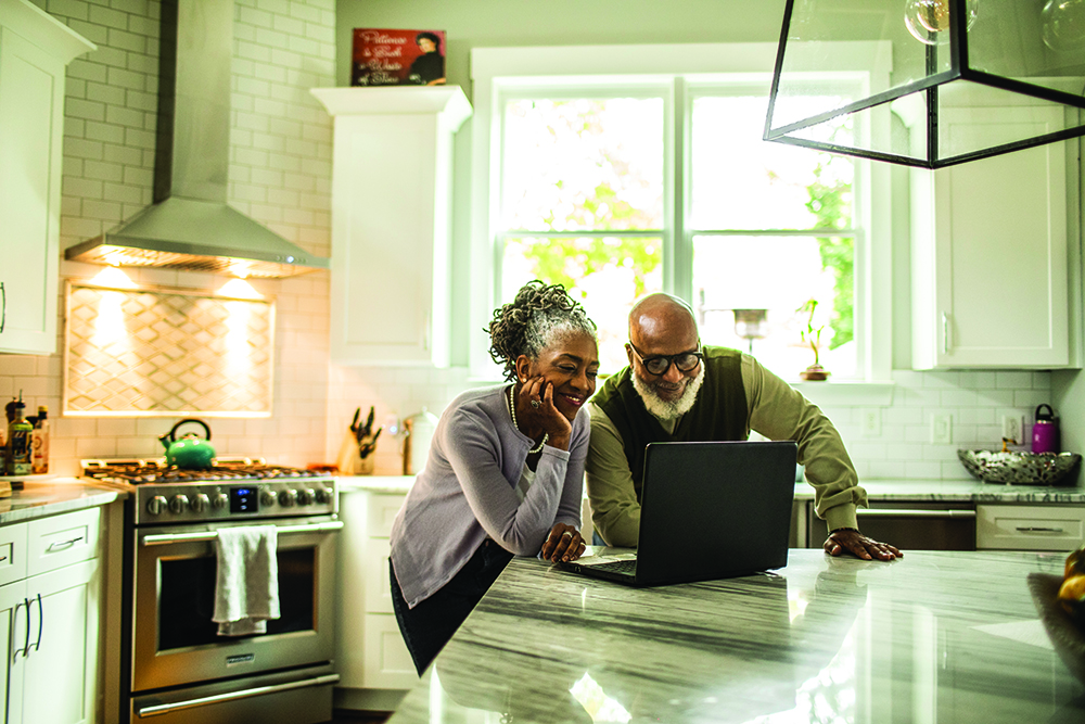 Couple in kitchen on laptop