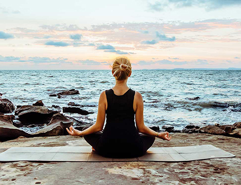 A woman meditating by the sea