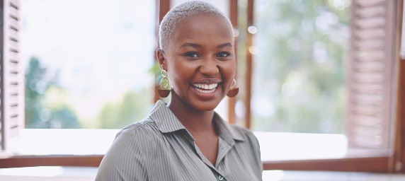 A woman smiles happily while holding her iPad.