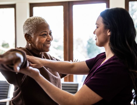 Nurse helping woman during physical therapy