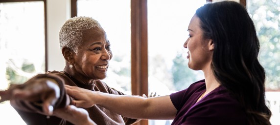 Nurse helping woman during physical therapy